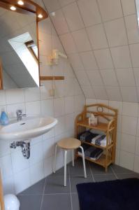 ein Badezimmer mit einem Waschbecken und einem Stuhl in der Unterkunft Studiowohnung mit dem gemütl Flair in Döse