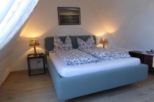 ein Schlafzimmer mit einer blauen Couch und zwei Lampen in der Unterkunft Studiowohnung mit dem gemütl Flair in Döse