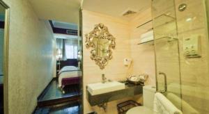 une salle de bain avec un lavabo et un miroir au mur dans l'établissement Guilin Sapphire hotel, à Guilin
