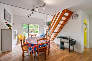 eine Küche und ein Esszimmer mit einem Tisch und einer Treppe in der Unterkunft Le Cottage du Tamaris - maison proche de la plage in Le Pouliguen + 4 Fotos