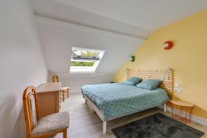 ein Schlafzimmer mit einem Bett und einem Schreibtisch in der Unterkunft Le Cottage du Tamaris - maison proche de la plage in Le Pouliguen