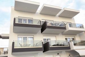 a building with glass balconies on it at Chroidis Appartment in Sozopoli
