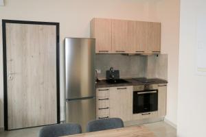 a kitchen with a stainless steel refrigerator and wooden cabinets at Chroidis Appartment in Sozopoli