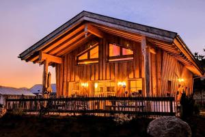 a log cabin with lights on in the evening at Inser Hof - Hüttenleben Bayern in Mauth +73 photos
