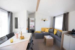 a living room with a couch and a table at Camping 4 étoiles - Piscine - ccaaeah in La Baule