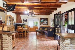 a living room with wooden ceilings and a dining room at Los Rosales in Burunchel