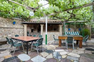 a patio with a wooden table and chairs and a table at Los Rosales in Burunchel