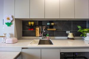 Una cocina con gabinetes blancos y un fregadero. en Nani Land, en Busan 19 fotos más