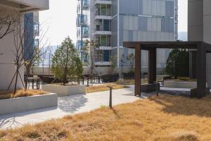 un parque con mesas y bancos frente a un edificio en Nani Land, en Busan