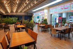 a restaurant with wooden tables and chairs and people sitting at tables at Almare Apartments in Vlorë +53 photos