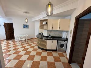 a kitchen with a checkered floor in a house at Casa nueva in Oulad Akkou