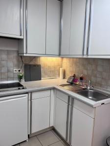 a kitchen with white cabinets and a sink at Fe-Wo im Herzen von Weingarten in Niederdorla