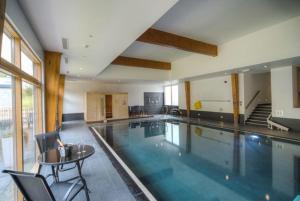 a large swimming pool with a table and chairs at House 31 in Looe