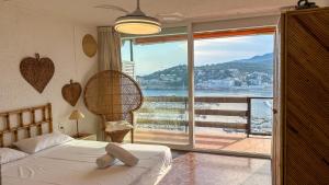 a bedroom with a bed and a large window with a view at An apartment with an ocean view in Sant Feliu de Guixols