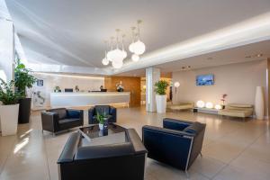 a lobby with couches and chairs in a building at iH Hotels Milano Watt 13 in Milan