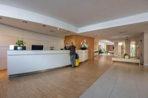 a man standing at a counter in an office lobby at iH Hotels Milano Watt 13 in Milan