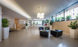 a lobby with couches and plants in a building at iH Hotels Milano Watt 13 in Milan