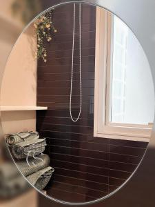 Un espejo circular en un baño con azulejos negros. en 辉煌象神庙主路地铁旁 全配套设施高端公寓 网红打卡地, en Bangkok