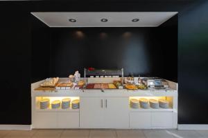 a kitchen with a counter with food on it at iH Hotels Milano Watt 13 in Milan