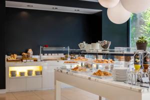 a buffet line with pastries and desserts on display at iH Hotels Milano Watt 13 in Milan