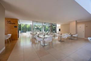 a dining room with white tables and white chairs at iH Hotels Milano Watt 13 in Milan