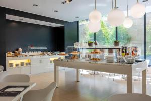a kitchen with a buffet of food on a table at iH Hotels Milano Watt 13 in Milan