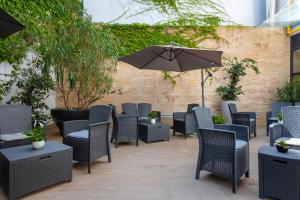 a patio with chairs and an umbrella at iH Hotels Milano Watt 13 in Milan