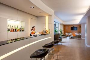 a woman standing at a bar in a hotel lobby at iH Hotels Milano Watt 13 in Milan