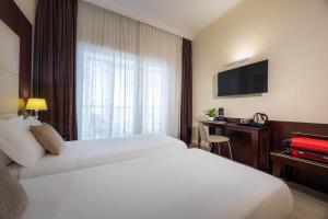 a hotel room with a bed and a television at iH Hotels Milano Watt 13 in Milan