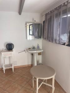 La salle de bains est pourvue d'un lavabo, d'une table et d'un tabouret. dans l'établissement Silva room 4 personnes, à La Celle-sous-Gouzon