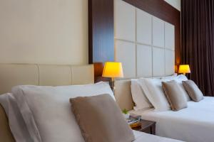 a hotel room with two beds with white pillows at iH Hotels Milano Watt 13 in Milan