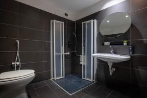 a bathroom with a toilet and a sink and a mirror at iH Hotels Milano Watt 13 in Milan
