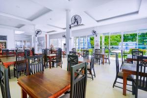 a restaurant with tables and chairs and windows at Lavendish Wild Safari in Wasgamuwa +68 photos