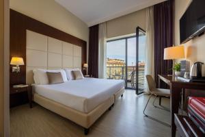 a hotel room with a large bed and a balcony at iH Hotels Milano Watt 13 in Milan