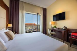 a hotel room with a bed and a desk and a window at iH Hotels Milano Watt 13 in Milan