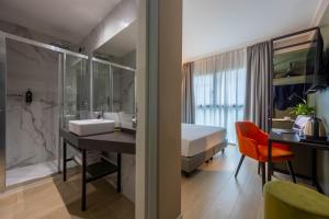 a bathroom with a sink and a bed in a room at iH Hotels Milano Watt 13 in Milan