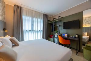 a hotel room with a large bed and a desk at iH Hotels Milano Watt 13 in Milan