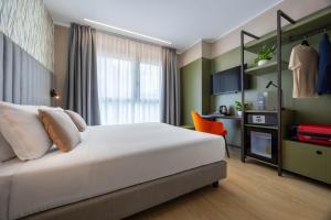 a bedroom with a white bed and a chair at iH Hotels Milano Watt 13 in Milan