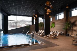 a hotel lobby with a pool and lounge chairs at Riddergaarden Hotel & Mountain Lodge, Beitostølen in Beitostøl