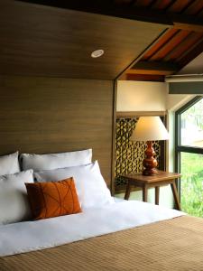 a bedroom with a bed and a table with a lamp at Một Nhà Thơ Homestay in Hương Trà