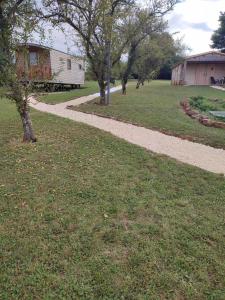 a walking path in a field with trees and a building at l'Eden du Sancerrois in Sens-Beaujeu +2 photos
