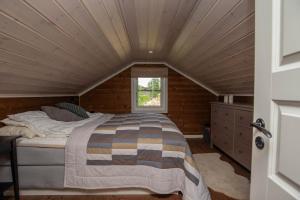 a bed in a room with a wooden ceiling at Vakker hytte med fantastisk utsikt in Geilo