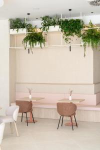a restaurant with tables and chairs and plants on the wall at Hotel RH Arena - Todo Incluido in Gandía