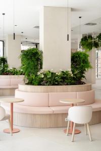 a seating area with tables and plants in a building at Hotel RH Arena - Todo Incluido in Gandía