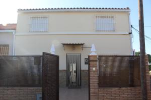 a white house with a black door and a fence at La Casica Vieja in Albujón