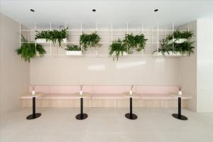 a waiting room with two tables and potted plants at Hotel RH Arena - Todo Incluido in Gandía