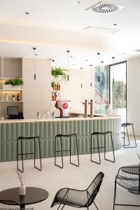a bar with chairs and tables in a room at Hotel RH Arena - Todo Incluido in Gandía