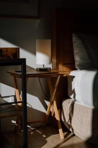 a wooden desk next to a bed with a lamp on it at Private guest suite in Central Wanaka in Wanaka
