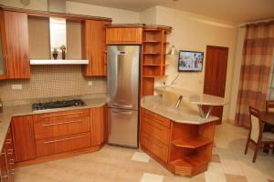 a kitchen with wooden cabinets and a stainless steel refrigerator at Anna Maria in Łomianki +21 photos