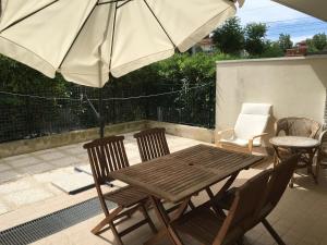 a wooden table and chairs with an umbrella on a patio at Casa Vacanze Marina Vecchia in Senigallia +6 photos